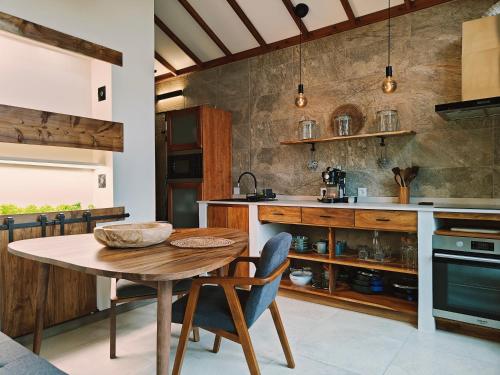 a kitchen with a wooden table and chairs at Casca de Noz - Modern Rustic Beach Getaway in Angra do Heroísmo