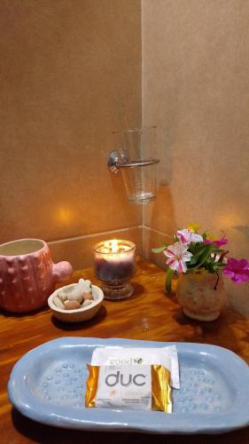 a table with a blue plate and a candle and flowers at Casa Villa Alba Carpinteria in Carpintería