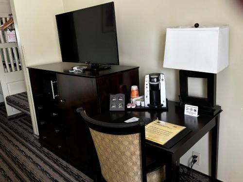 a desk with a television and a desk with a lamp at Navajo Nation Inn in Window Rock