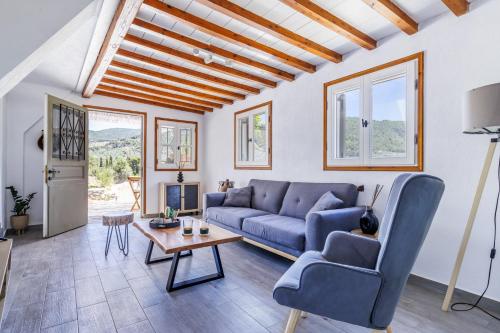 a living room with a blue couch and a table at Solea Cottage - Bright Escape in Skopelos in Skopelos Town
