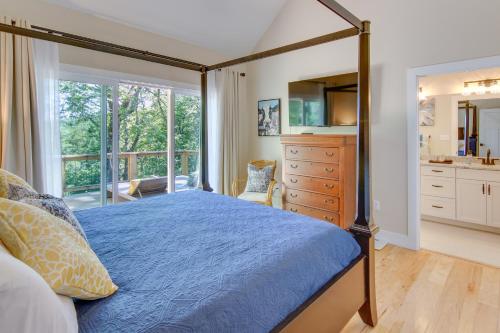 a bedroom with a bed with a blue comforter at Modern Hendersonville Home Deck and Mountain Views! in Hendersonville