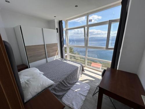 Un dormitorio con una cama y una ventana grande. en Sarchal, en Ceuta