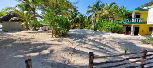 a fence in front of a house with palm trees at XpuHa Bonanza in Xpu Ha