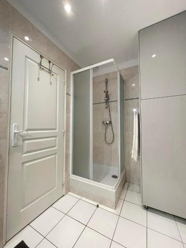 une salle de bain avec une douche avec une porte vitrée dans l'établissement Villa Zen, à Sartrouville