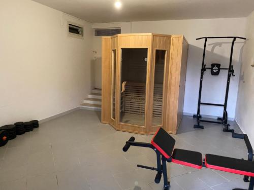 a room with a gym with a cabinet and weights at Villa Spaziosa con vista mare in Capitello
