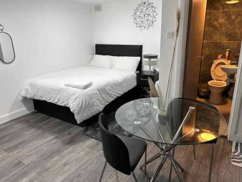 a bedroom with a bed and a glass table at ChaRloHub 01 in Coventry