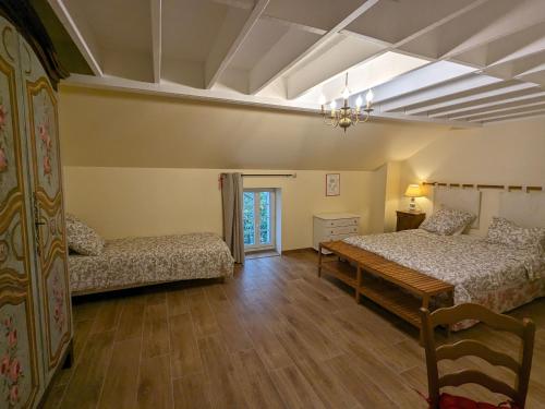 a bedroom with two beds and a table and a couch at Gîte chaleureux avec jardin, accueil chevaux, proche Loire à Vélo et sites historiques - FR-1-590-415 in Sigloy