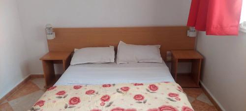 a bed with two pillows and a blanket on it at Residence Yasamine Ain El Turck in 'Aïn el Turk