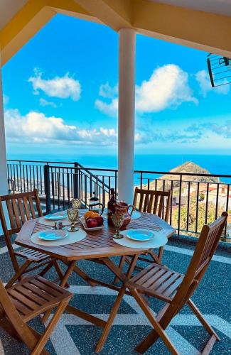 a table on a balcony with a view of the ocean at BoaVista- 2 bed house -COSY PANORAMIC -SEA - MOUNTAIN VIEW in Campanário