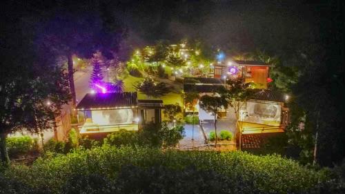 a group of houses with lights on them at night at Heaven Hill Camping in Ban Thung Na