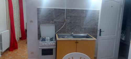 a small kitchen with a sink and a stove at Residence Yasamine Ain El Turck in 'Aïn el Turk