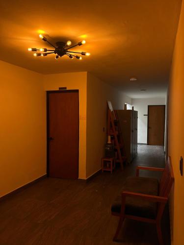 a living room with a ceiling fan and a door at El salto de Camela Hostal in Uruapan del Progreso