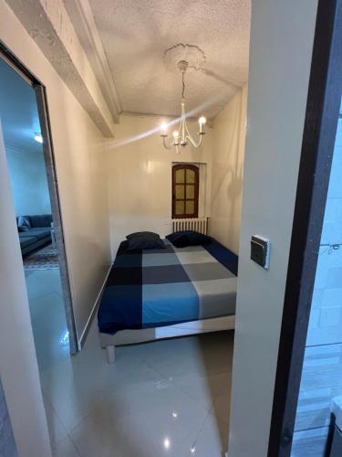 une chambre avec un lit et un lustre dans l'établissement Maisonnette de ville, à Aubervilliers