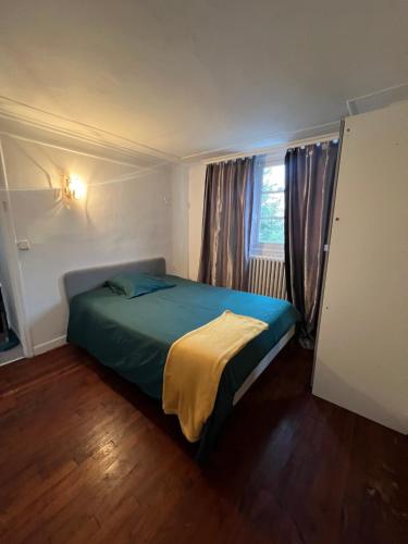 une chambre avec un lit dans une pièce avec une fenêtre dans l'établissement Maisonnette de ville, à Aubervilliers