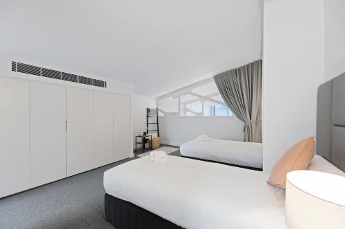 a bedroom with two beds and a window at Stanley Lane Residence Darlinghurst in Sydney