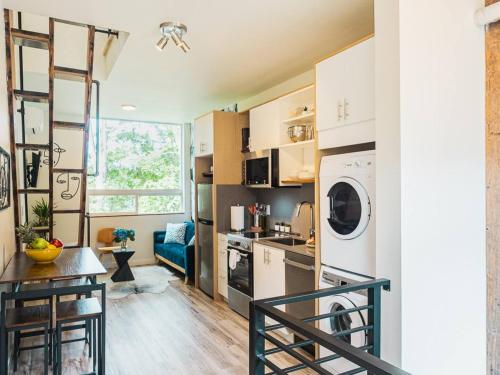 a kitchen and living room with a washer and dryer at "Sauna-fication" in West Seattle in Seattle