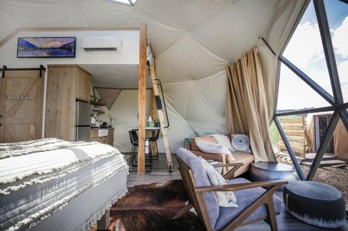 a bedroom with a bed and a chair in a tent at Pure Heart Retreat in Cody