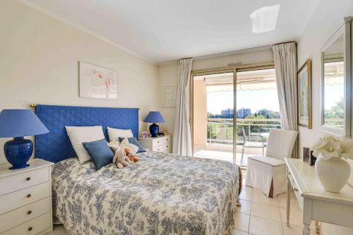 une chambre avec un lit avec un ours en peluche dessus dans l'établissement T3 in Mandelieu with Terrace AC Parking Swimming Pool Tennis - BENAKEY, à Mandelieu-la-Napoule