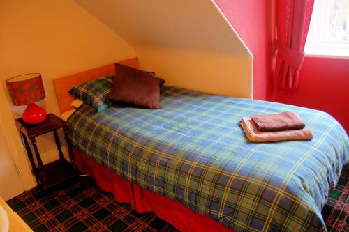 a bedroom with a bed with two towels on it at Atticus Central Guest House in Aberdeen