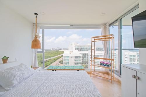 Un dormitorio con una cama y una ventana grande. en Sensacional! Apartamento Cartagena Morros Sonesta, en Cartagena de Indias