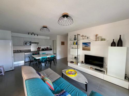 un salon avec un canapé bleu et une cuisine dans l'établissement Appartement T4 avec Terrasse, Piscine et Proche Dune du Pyla - FR-1-319-154, à La Teste-de-Buch