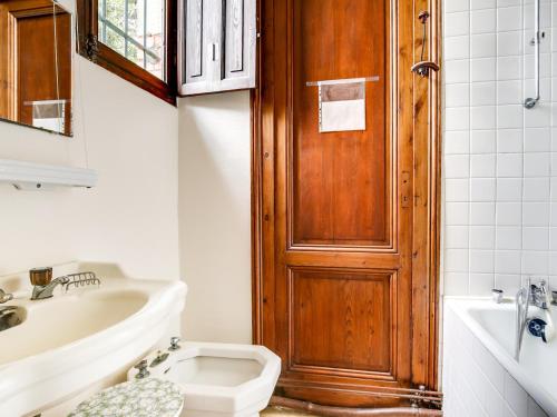 une salle de bain avec toilettes et porte en bois dans l'établissement Villa Arcachonnaise 100m², 3 chambres, jardin, terrasse, parking - Quartier Ville d'Hiver, Arcachon - FR-1-474-47, à Arcachon
