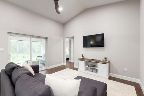 a living room with a couch and a flat screen tv at Royal Highlands Retreat in Weeki Wachee