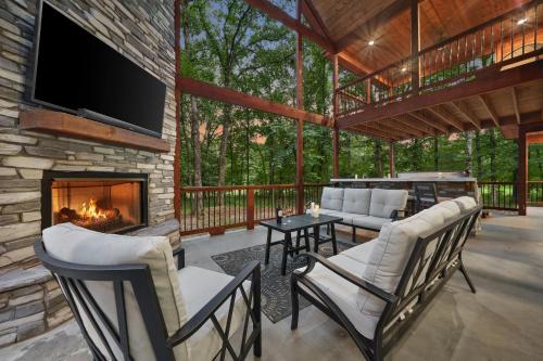 a screened in porch with a fireplace and chairs at Meadows Edge Cabin in Broken Bow