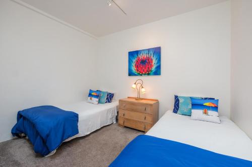 OneroaにあるApartment Oneroa Central with Sea Viewsのベッド2台とドレッサーのある寝室