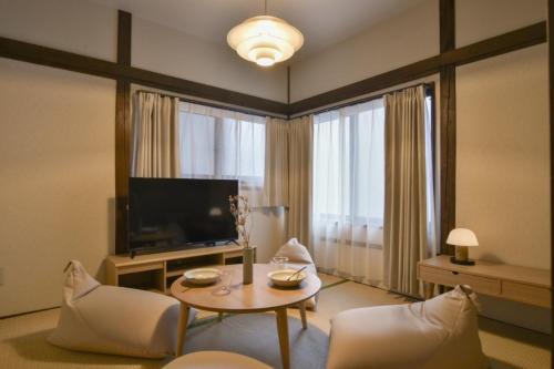 a living room with a television and a table and chairs at 森下別邸 in Tokyo