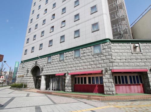 a large white building with a red door at Island Hotel in Nagano