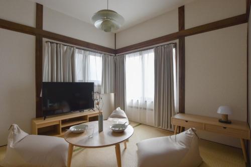 a living room with a television and a table and chairs at 森下別邸 in Tokyo