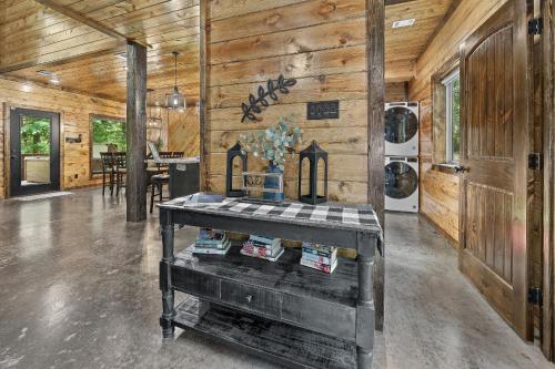a room with a wooden wall with a table in it at Meadows Edge Cabin in Broken Bow