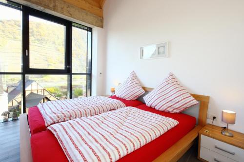Cama roja en habitación con ventana grande en Alte Scheune Bruns, en Lehmen
