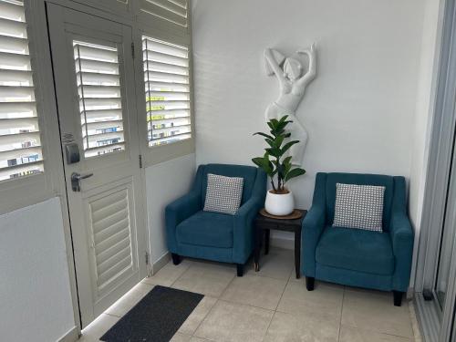 a hallway with two blue chairs and a statue at 347 Paradiso Kingscliff Beach 3 Bedroom Private Rooftop in Kingscliff