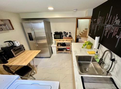 a kitchen with a sink and a stainless steel refrigerator at Cozy PDX Hideout, Ideal Location in Portland