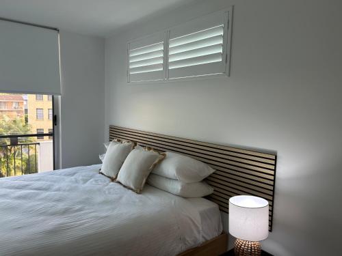 a white bedroom with a bed with pillows and a window at 347 Paradiso Kingscliff Beach 3 Bedroom Private Rooftop in Kingscliff