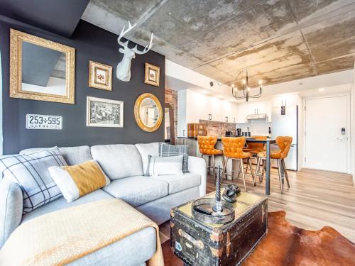 a living room with a couch and a table at Rustic, Downtown Quebec, Rooftop pool, 2 bedrooms AND 2 bathrooms -up to 6 guests in Quebec City