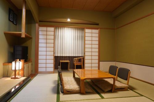 a room with a wooden table and chairs at ホテルベイグランド国東 in Kunisaki