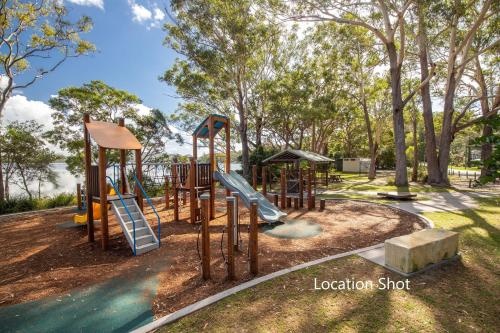 a playground with slides in a park with trees at Dux Nutz in Smiths Lake