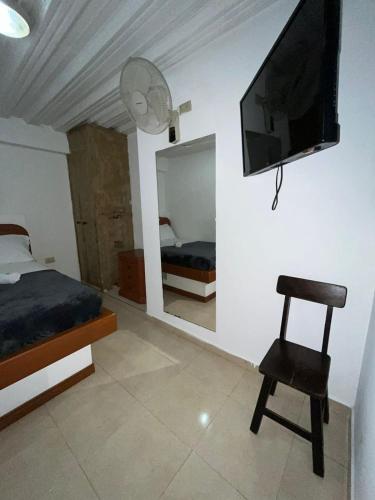 a bedroom with a bed and a television on a wall at Hotel San Diego DOSQUEBRADAS in Dosquebradas