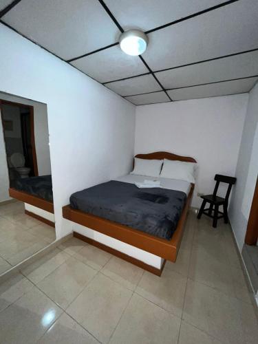 a bedroom with a bed and a chair in it at Hotel San Diego DOSQUEBRADAS in Dosquebradas