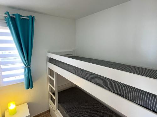 une chambre avec deux lits superposés et une fenêtre dans l'établissement Saint-Cyprien : Appt front de mer avec piscine, parking et clim - FR-1-753-25, à Saint-Cyprien