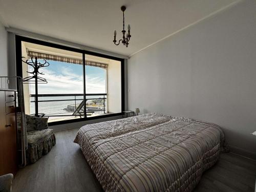 une chambre avec un lit et une grande fenêtre dans l'établissement Appartement pour 5 personnes avec WiFi et parking à Royan - FR-1-494-197, à Royan