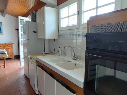 une cuisine avec un évier et un micro-ondes dans l'établissement Maison oléronaise avec piscine, jardin clos et à 1km de la plage de Foulerot - FR-1-778-30, à Saint-Georges-dʼOléron