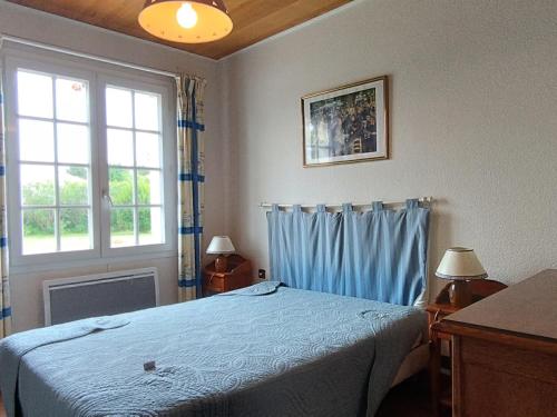 une chambre avec un lit bleu et une fenêtre dans l'établissement Maison oléronaise avec piscine, jardin clos et à 1km de la plage de Foulerot - FR-1-778-30, à Saint-Georges-dʼOléron