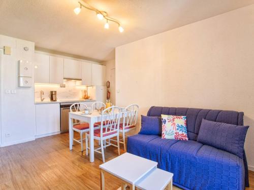 un salon avec un canapé et une table et une cuisine dans l'établissement Appartement lumineux avec balcons et stationnement privatif - FR-1-788-22, à Varaville