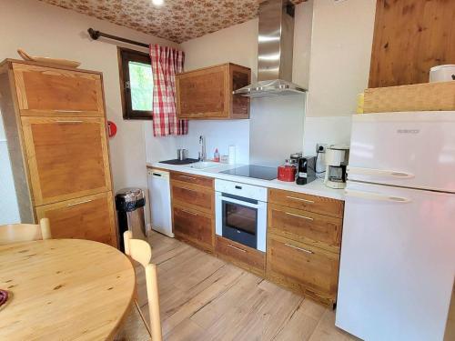 Elle comprend une petite cuisine équipée d'un réfrigérateur blanc et d'une table. dans l'établissement Appartement 6 pers - Pied des pistes - 1 chambre - Rando - Bien équipé - Saint-Michel-de-Chaillol - FR-1-393-175, à Saint-Michel-de-Chaillol