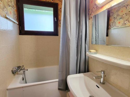 La salle de bains est pourvue d'un lavabo, d'une baignoire et d'une fenêtre. dans l'établissement Appartement 6 pers - Pied des pistes - 1 chambre - Rando - Bien équipé - Saint-Michel-de-Chaillol - FR-1-393-175, à Saint-Michel-de-Chaillol
