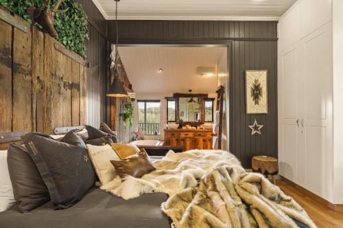 a living room with a bed with a blanket at Beam Creek Cottage - Montville in Montville